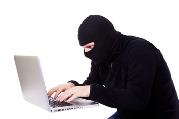 pirate informatiqye en cagoule devant son ordianteur