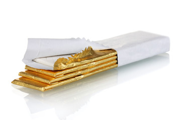 chewing gums wrapped in golden foil, isolated on white