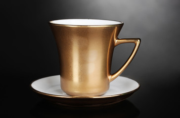 golden cup of coffee on gray background