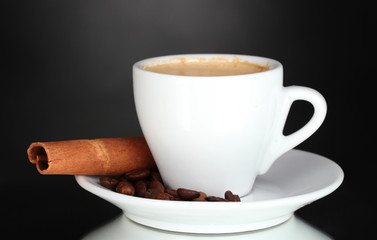 cup of coffee, cinnamon and coffee beans on black background