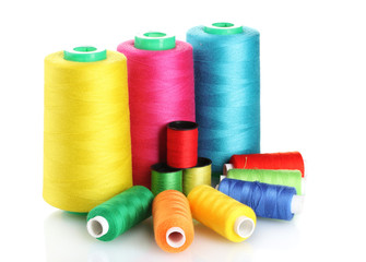 Many-coloured bobbins of thread isolated on white