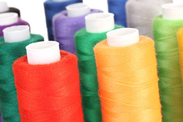 Many-coloured bobbins of thread closeup