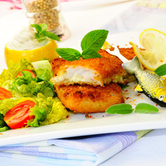 Frittiertes Seelachsfilet auf frischem Salat