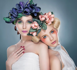 Two graceful nymphs - lovely brunette and pretty blonde touching