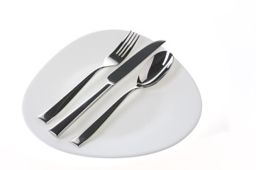Fork, spoon and  knife on a plate over white