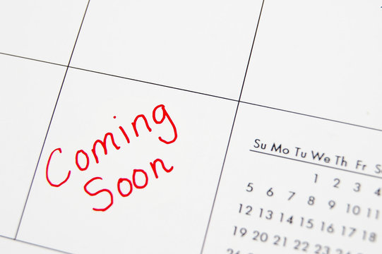 Closeup of a calendar with "Coming Soon" text in  red