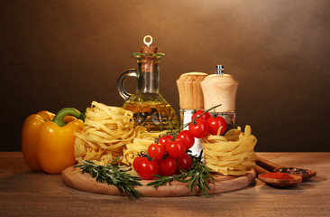 noodles in bowl, jar of oil, spices and vegetables