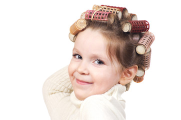 Beautiful little girl with curlers on her head.