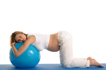 pregnant woman practicing yoga with blue ball