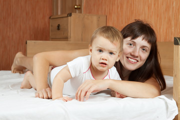 Happy mother with  baby  on  sheet