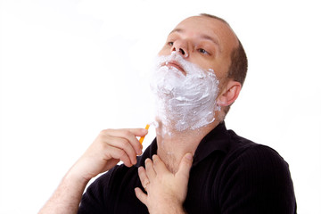 homme qui se rase avec rasoir manuel et mousse