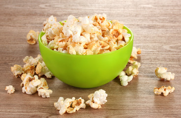 popcorn in bright plastic bowl on wooden table