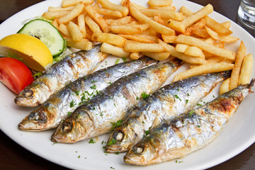 Sardinen mit Pommes auf einem Teller