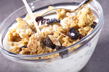 Müslie mit Früchten in Glasschale und Milch Einschank Nahaufnahme