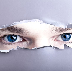 Augen starren durch Papierloch