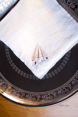 Luxury towel with shells in silver scale on wooden table