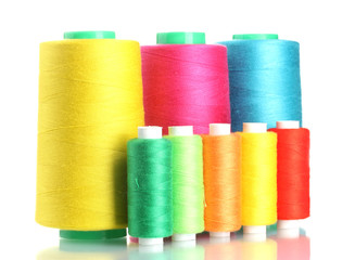 Many-coloured bobbins of thread isolated on white