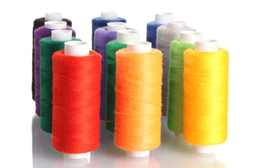 Many-coloured bobbins of thread isolated on white