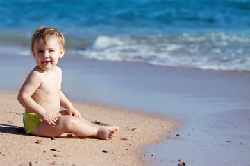 Fototapeta na wymiar Happy toddler on sand beach