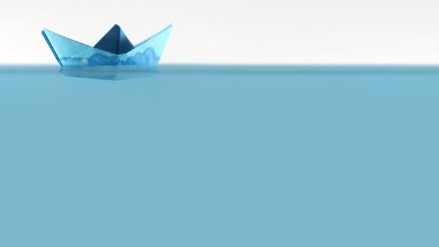 Blue paper boat on surfaces of water