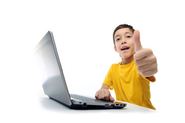 young boy in yellow t-shirt with laptop showing thumbs up at cam