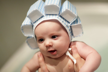 Baby boy in bath in swim cap