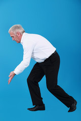 A mature businessman miming.