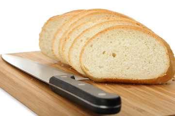 The cut bread on a chopping board with a knife