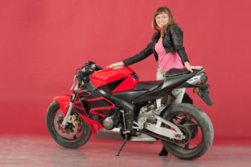 Fototapeta na wymiar Young girl with bike, on red background
