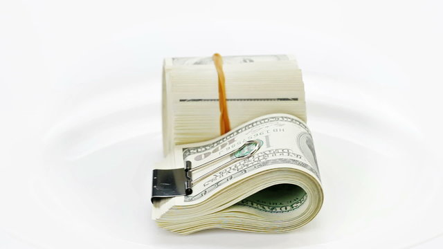 Bundle of many 100 dollar notes rotating on white background