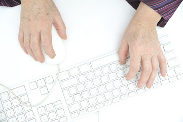 Hands of an old female typing on the keyboard