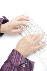 Hands of an old female typing on the keyboard