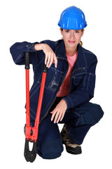A female construction worker with pliers.