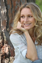 Fototapeta premium woman sitting against tree