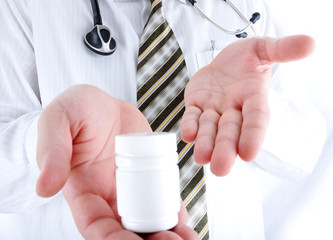 Fototapeta na wymiar Closeup, doctor holding little pills bottle - copy space for you