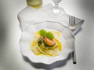 pesto ravioli with shrimp and parmesan flakes