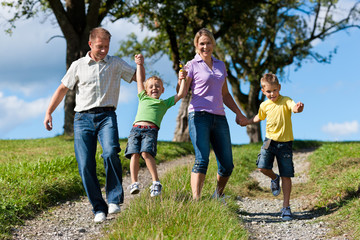 Family outdoors is running on a dirt path