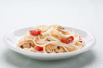 Tagliatelle sautéed with tomatoes and mushrooms