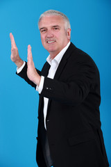 Businessman pretending to push wall