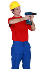 Young laborer using drill