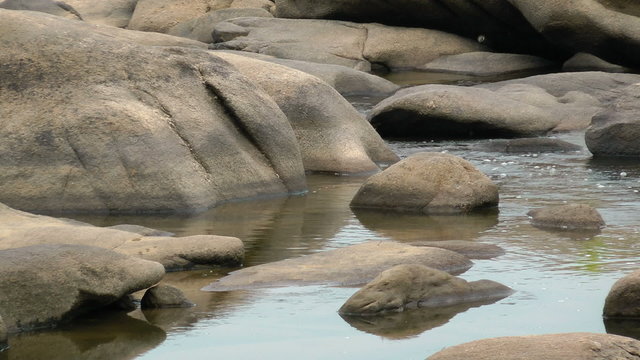 Water flowing around big river rocks