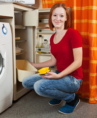 woman  defrosting the refrigerator