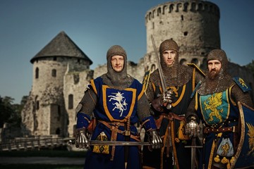 Trois chevaliers contre château médiéval.
