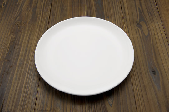 木のテーブルに白色のお皿のアップ
