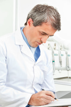 Zahnarzt kontrolliert Checkliste