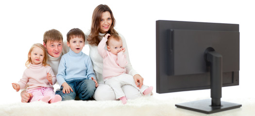 happy family sitting on floor and watching TV or monitor with gr
