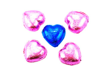 Wrapped chocolate hearts on white background