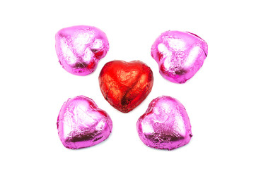 Wrapped chocolate hearts on white background