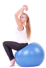 Young woman in gym with a blue ball