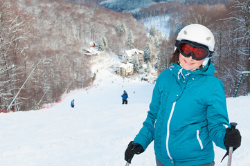Fototapeta na wymiar Young woman with ski against mountains